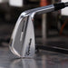 A TaylorMade RORS PROTO Golf club head on a metallic surface with a blurred background