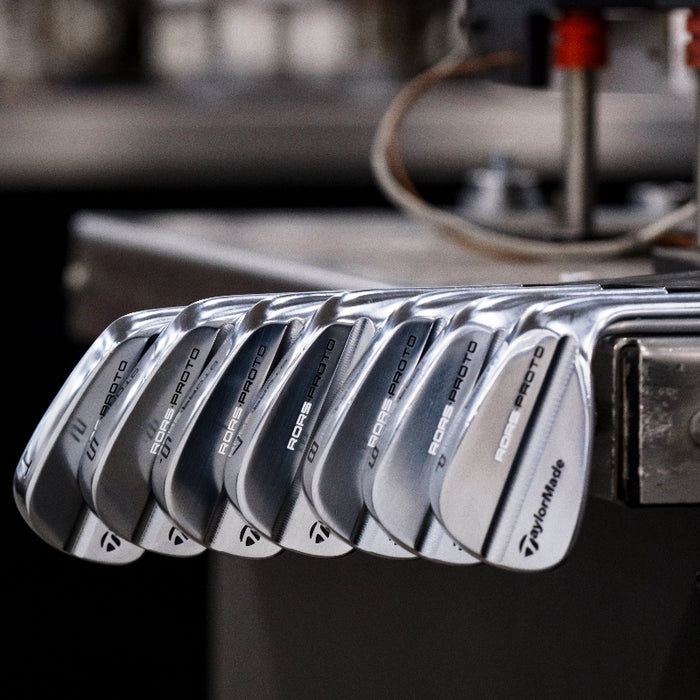 A set of Taylormade RORS•PROTO Irons with a silver finish, displayed in a row with the brand and model name visible.